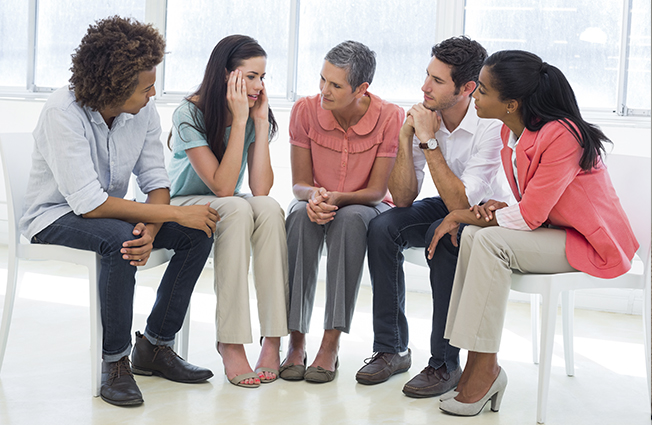 Group sitting in circle for therapy session.