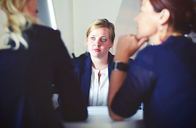 Professional woman sitting across the table from two women